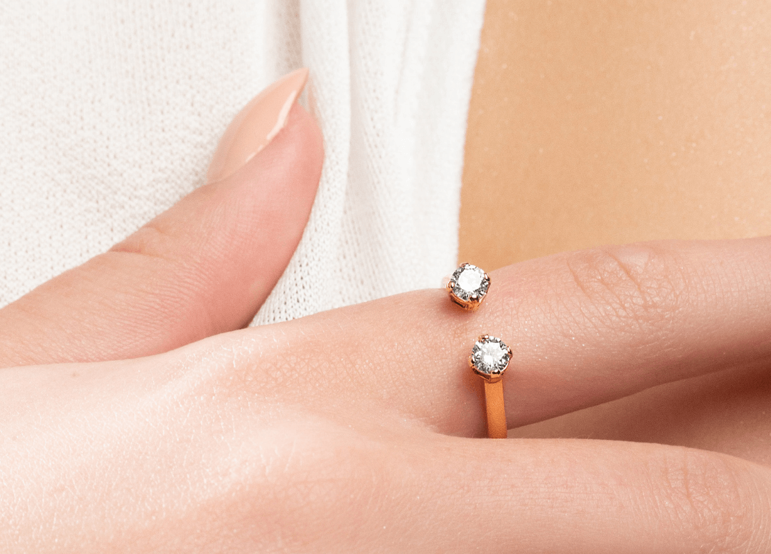 Ženska ruka s prekrasnim prstenom s dva blistava dijamanta.