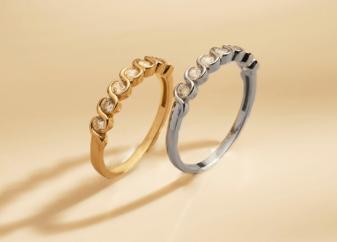  Dva elegantna Dodić prstena, jedan zlatni i jedan od bijelog zlata, svjetlucaju ljepotom i profinjenošću.